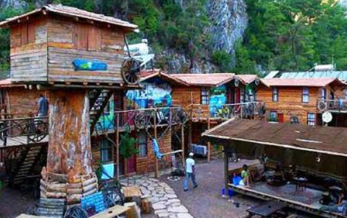 Tarihi kalıntıların içinden geçen nehir ve meşhur Olimpos ağaç evlerinin bohem görüntüsü.